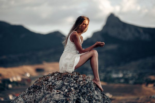 девушка сидит на камне