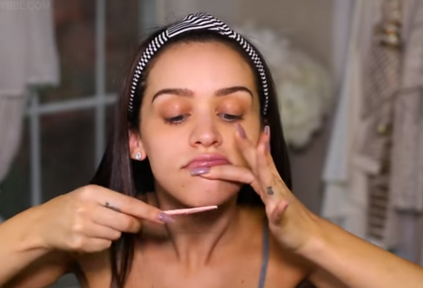 Женщина удаляет волосы на лице