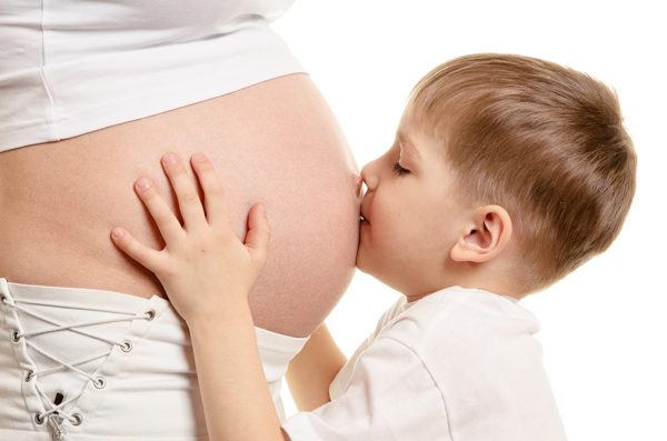 Малыш целует живот беременной