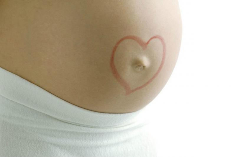 Нарисованное сердечко вокруг пупка беременной