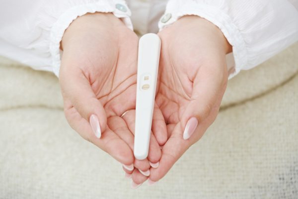 Положительный тест на беременность в руках