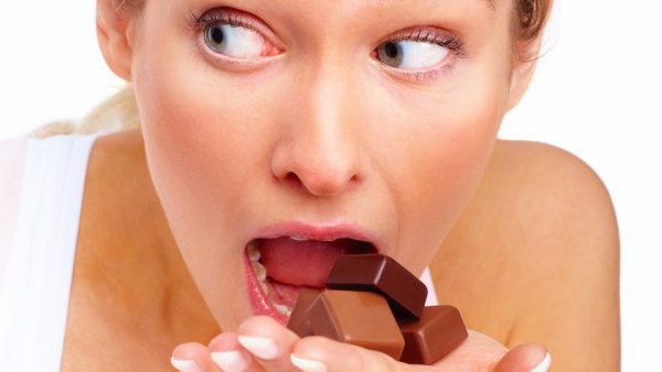 Женщина ест конфеты