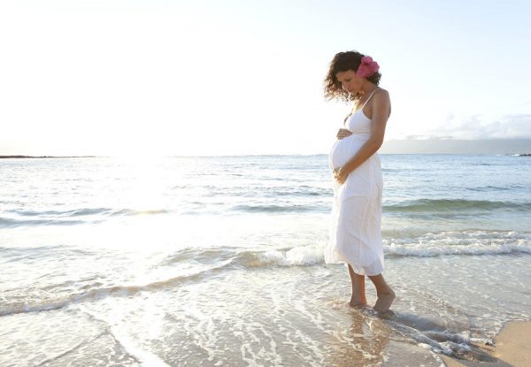 беременная гуляет по берегу моря