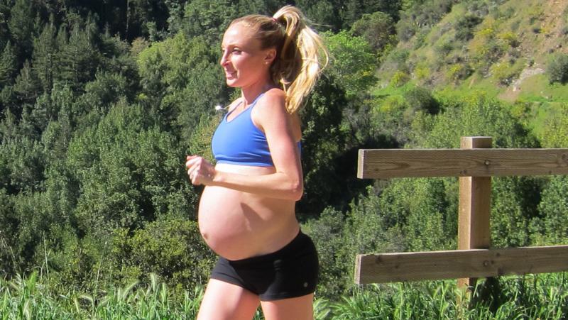 Беременная женщина бежит трусцой