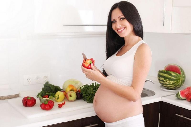 Беременная женщина готовит обед