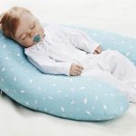 Младенец на подушке в форме рогалика