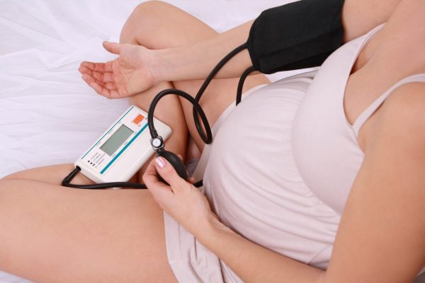 Беременная женщина измеряет давление