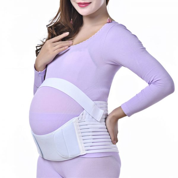 Беременная женщина в бандаже поверх одежды