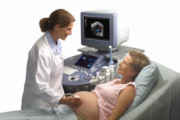 беременная лежит на кушетке, врач проводит УЗИ