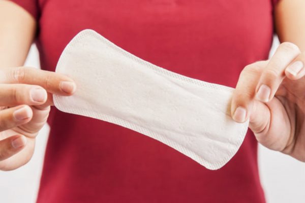 Гигиеническая прокладка в женских руках