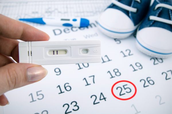 Тест на беременность, календарь и детские пинетки
