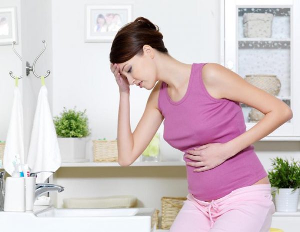 беременная женщина сидит у раковины