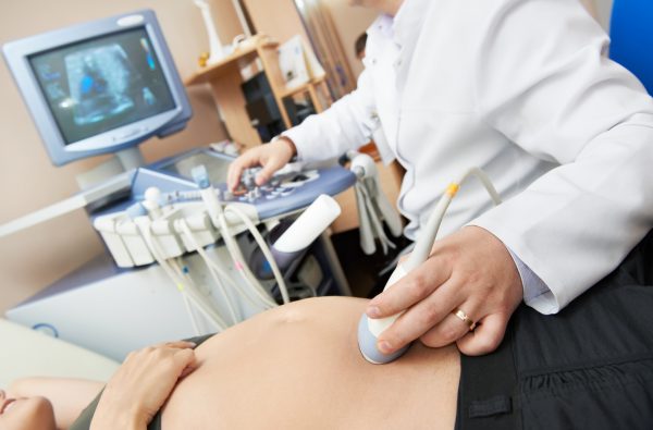 Врач проводит ультразвуковое исследование беременной женщине