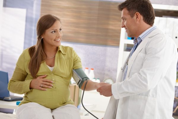 Доктор измеряет давление беременной