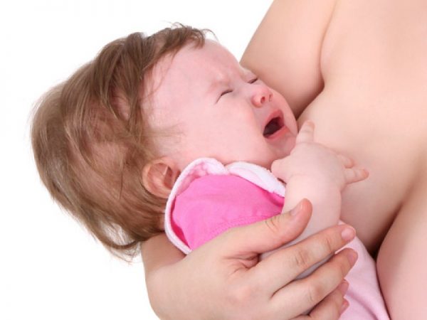 младенец плачет у груди мамы