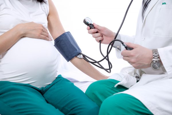 врач измеряет у беременной давление