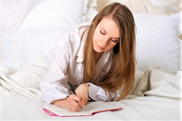 Женщина пишет в кровати