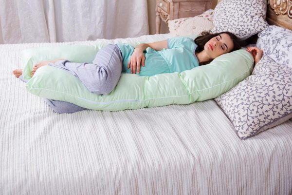 Беременная спит на специальной подушке