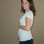 Женщина на 17-й неделе беременности держится за живот