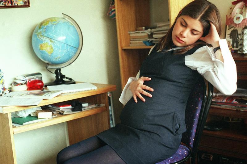 Беременная школьница засыпает на стуле