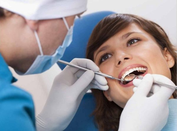 стоматолог проверяет зубы у женщины