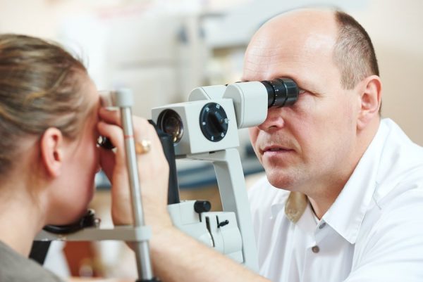 офтальмолог проверяет состояние глаз у девушки