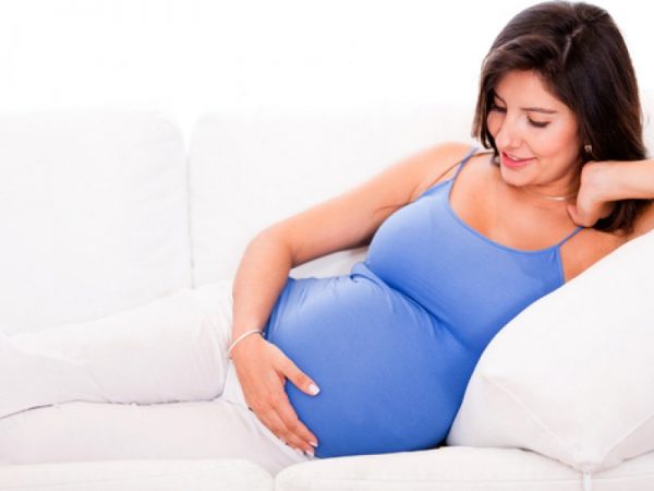 немолодая беременная полулежит на диване