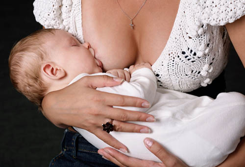 Младенец сосёт мамину грудь