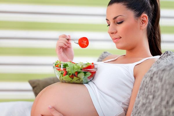 беременная женщина ест салат