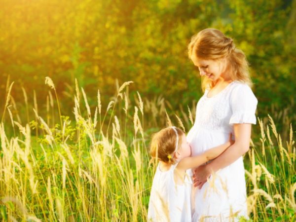 беременная на лесной поляне с дочкой