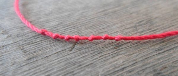 Красная нить с узелками
